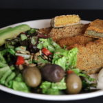 Plate served with salad, olives, mayonnaise and lentil tofu steaks